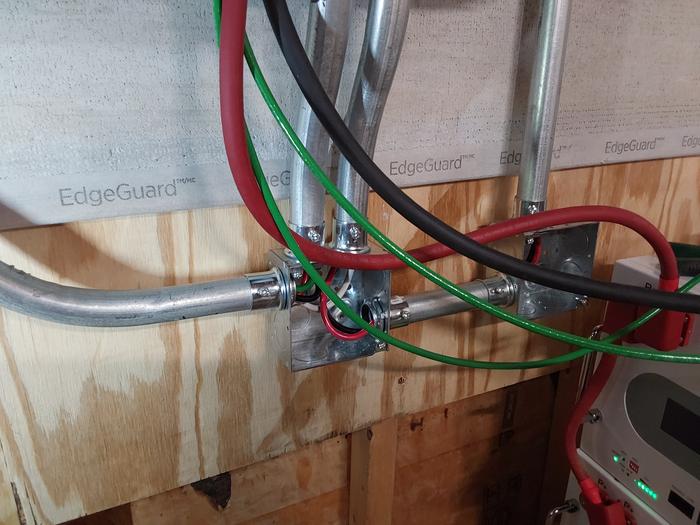 The low voltage (battery cables) isn't required to be in conduit