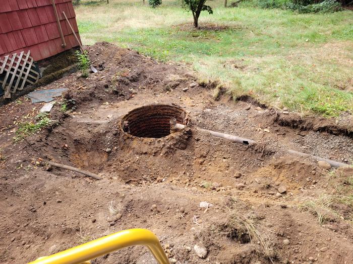 Before installing the new tank, shows the failed septic tank exposed so it could be pumped out before removal.