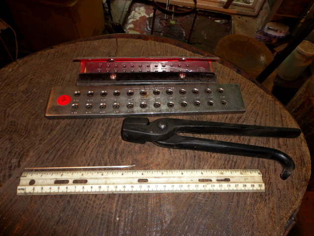 This shows the thin strip of silver roughly 5.5 inches long. Also in the photo are my draw plates and tongs,