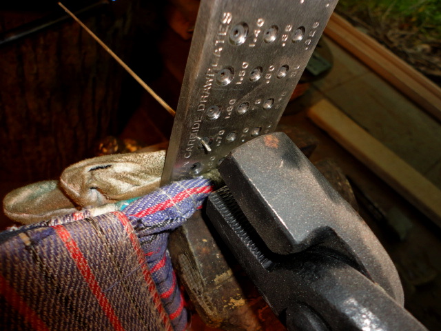 I've got the plate clamped in a vise, with a glove wrapped around it to protect from marring. The wire is about to be drawn through it's initial pull.