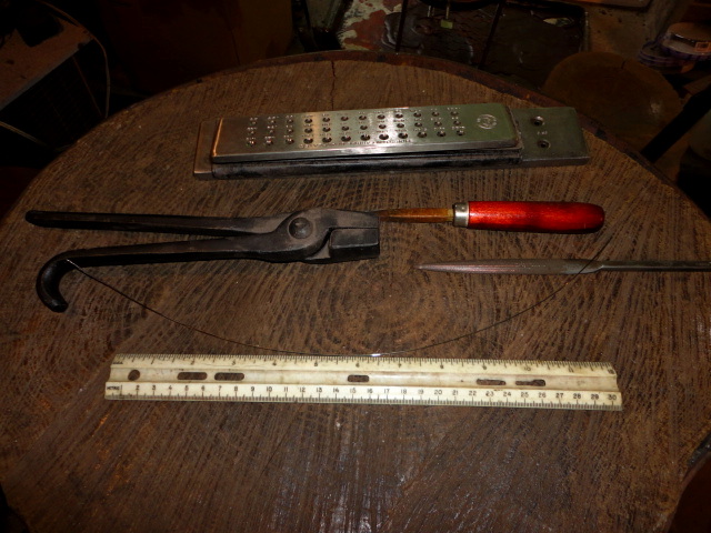 The final results showing a much longer wire, roughly 15 inches, and the tools used again.