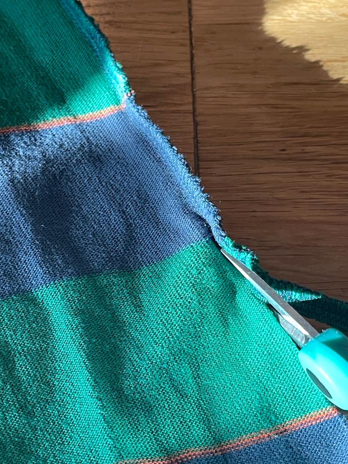 trimming off seam stitching with scissors