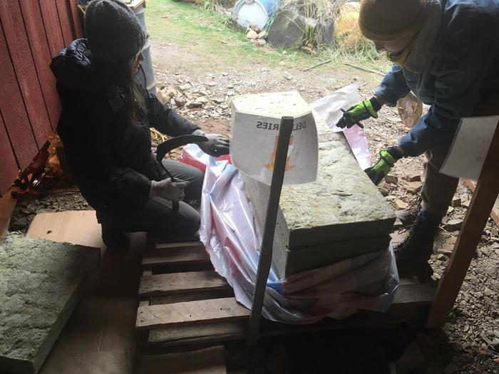 Cutting insulation for red cabin amongst the snows