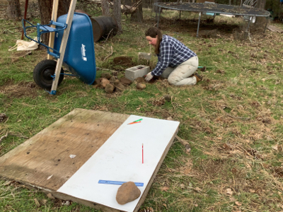 back filling with soil and rocks to stabilize cinder block marker