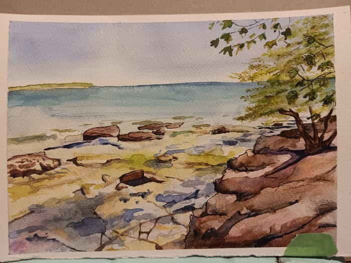 Rocky lakeshore across the bay from a sandy beach