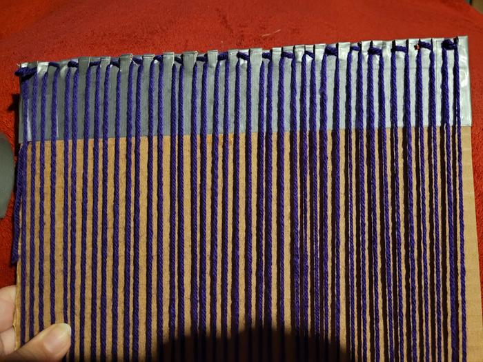 close-up of cardboard loom threaded