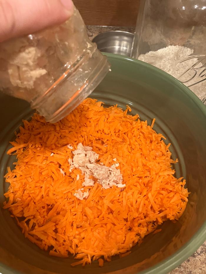 Carrots in a bowl and adding chicken