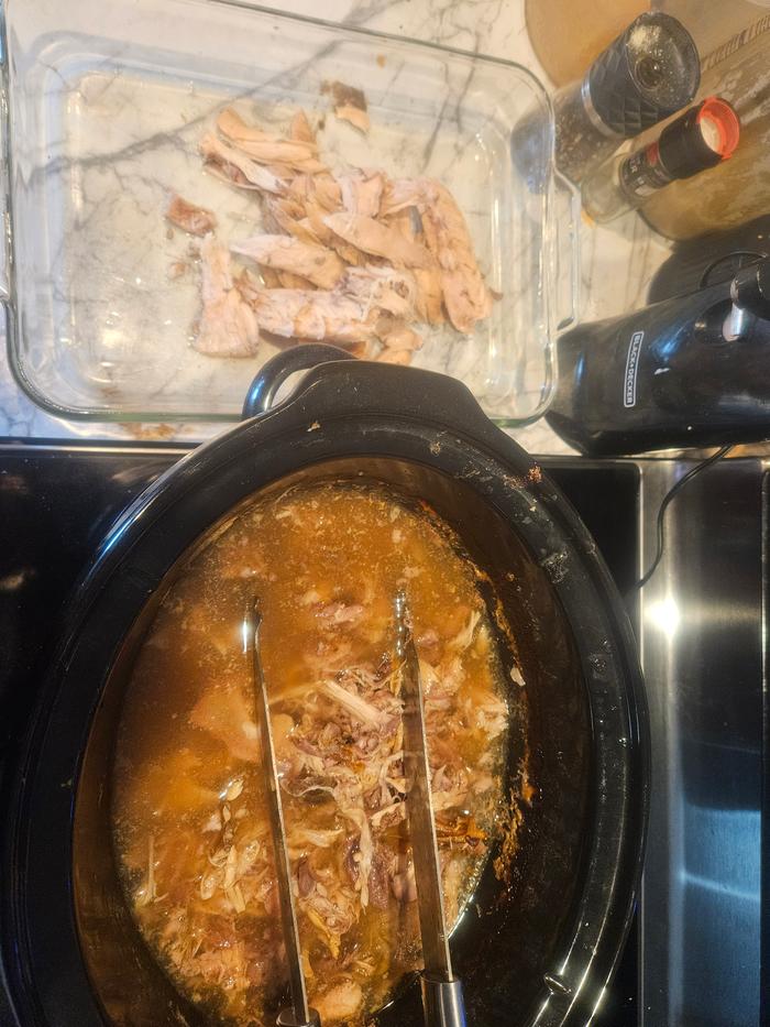 Stripping rabbit carcass for the caserole. I first cooked the rabbit in a slow cooker, then measured all the ingredients with the rabbit into this glassware baking dish. It's going into the oven under the stove top in this picture