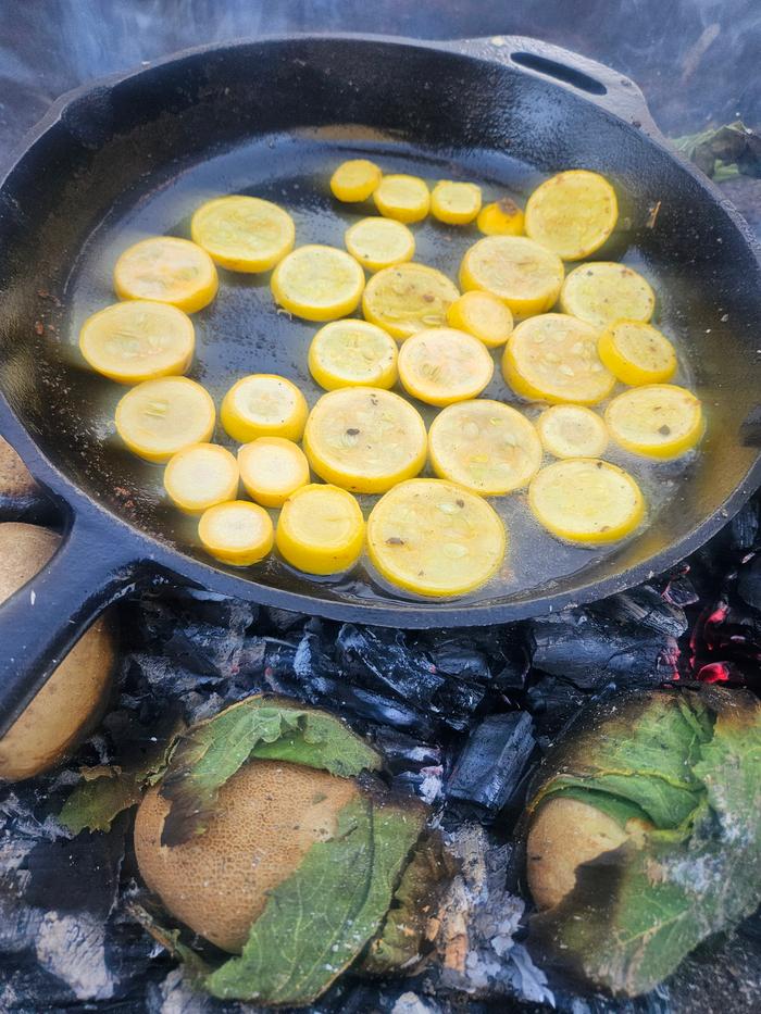 Squash in skillet over coals