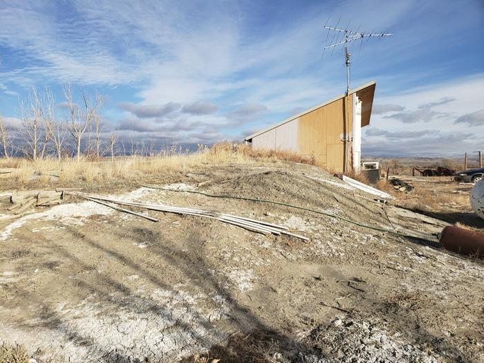 building site for earth berm greenhouse