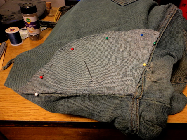 Partway through, the patch is pinned in place and being sewn on around the edges.