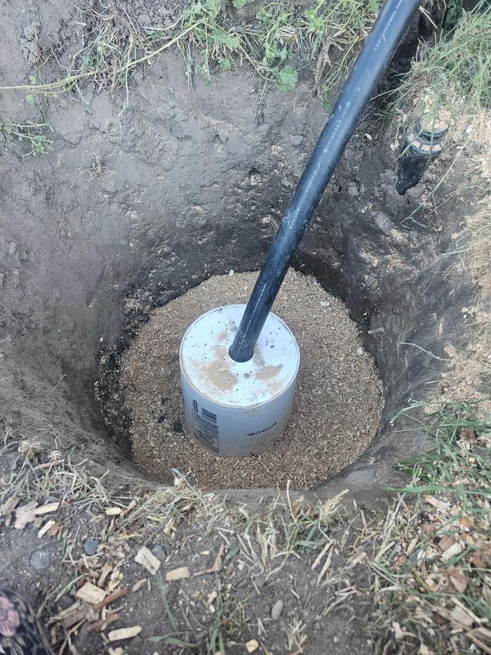 Wood chips beginning to fill in the hole. The bucket is upside down, riddled with holes, and fitted with a 1.5 inch pip that will eventually connect to my shower