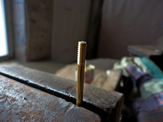 The threaded end of the brass rod.