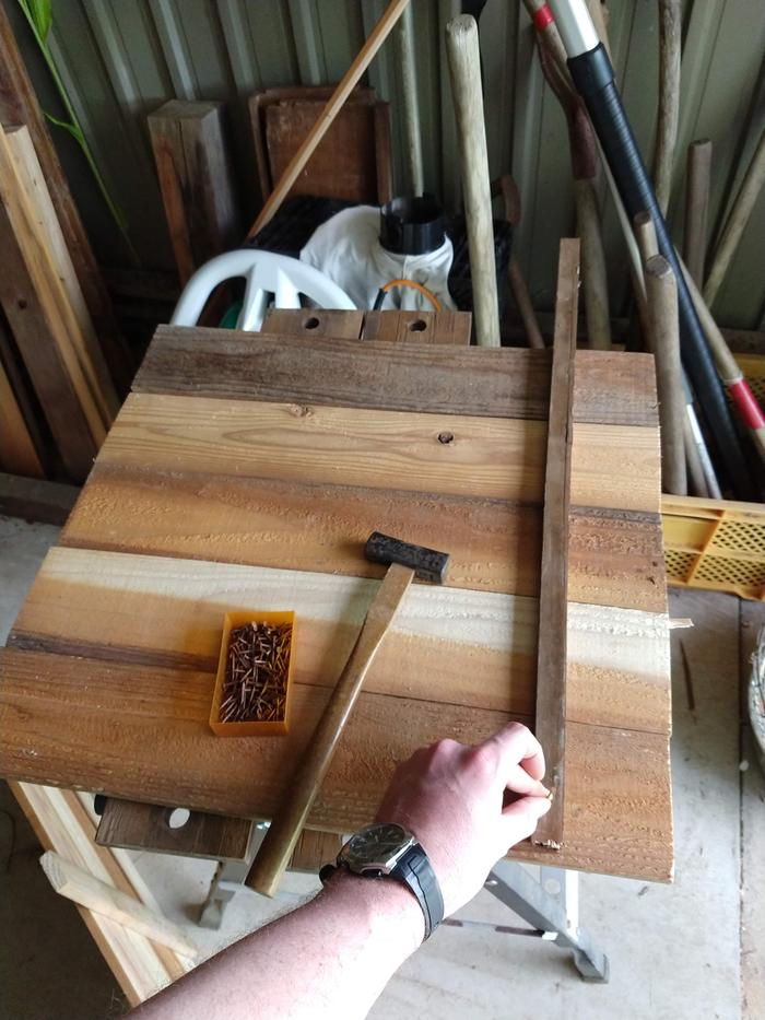 I tried to put a panel together on top of the workbench which resulted in dropping all of the slats and spilling my box of nails... I then worked on the concrete floor with better results.