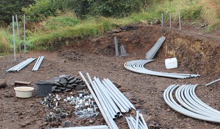 polytunnel frame laid out with first anchor poles loosely in position