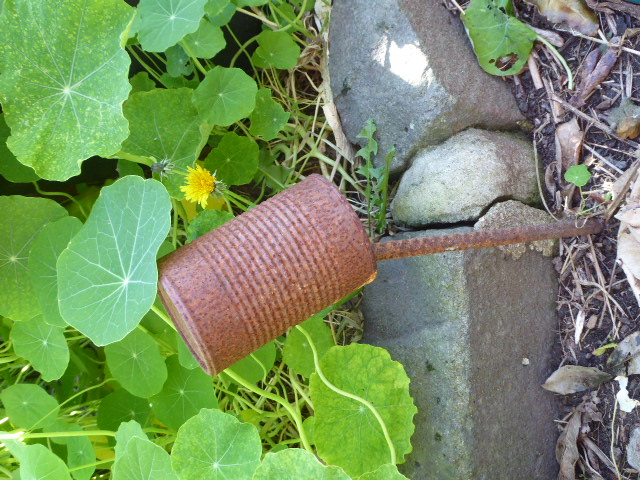 Stake in ground, and if I leave it, I cover it with a tin can to protect my legs in-between seasons!!