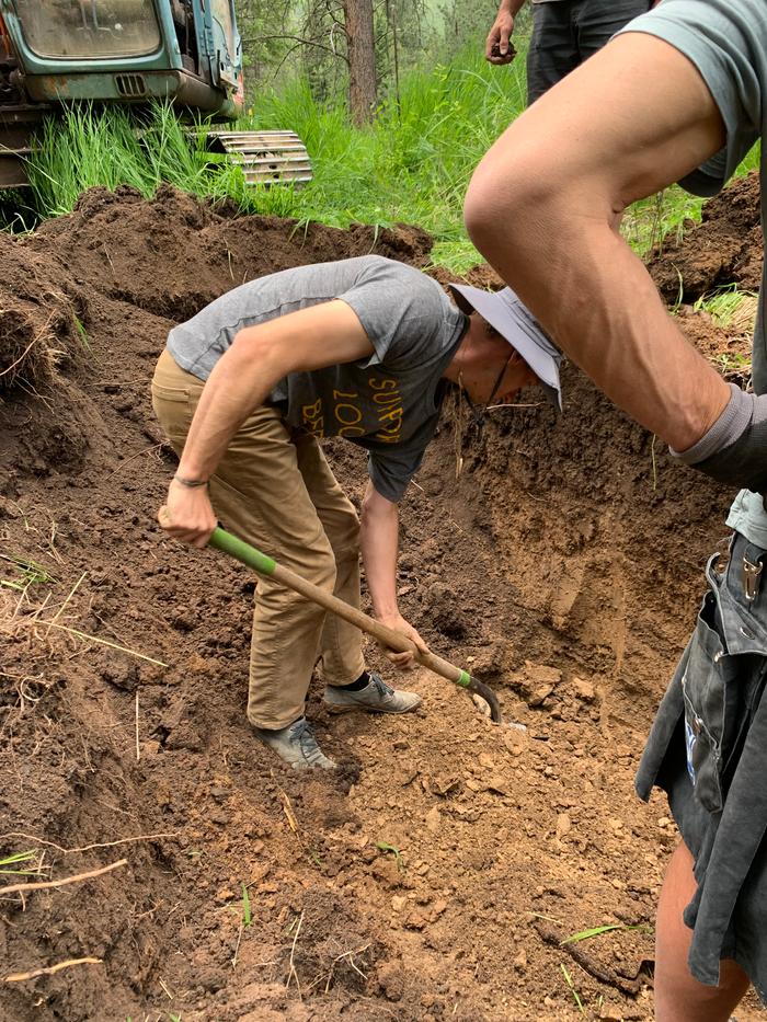 man-digging-for-pieces-of-clay-from-test-trench-at-Wheaton-Labs_close-up