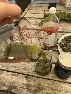 pouring oil into storage jar after straining