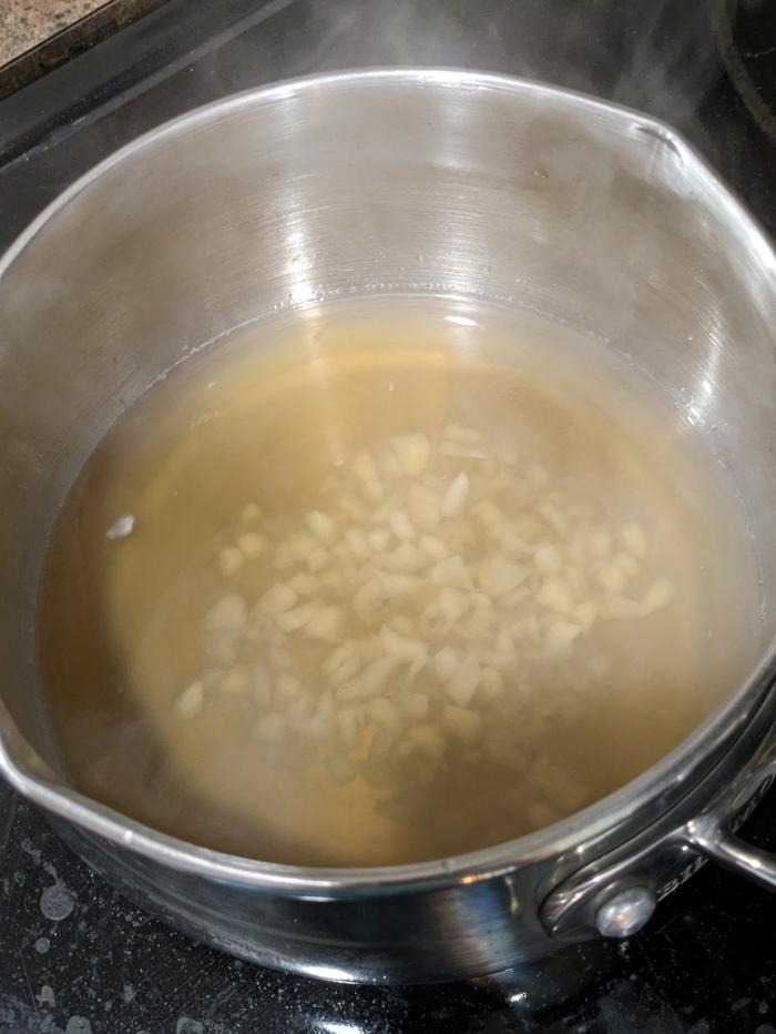 Simmering garlic in chicken broth