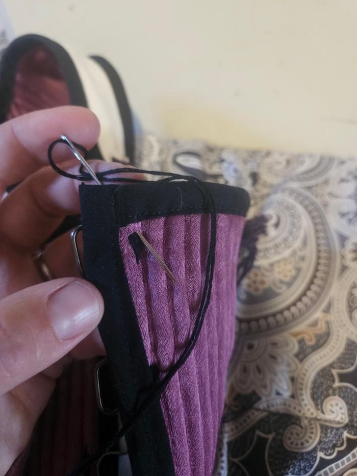 me, actually sewing. hand sewing on the clasps
