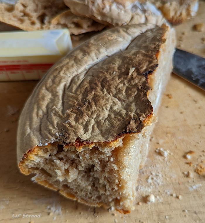 This is what a loaf of bread looks like when the parchment paper is embedded in the crust.