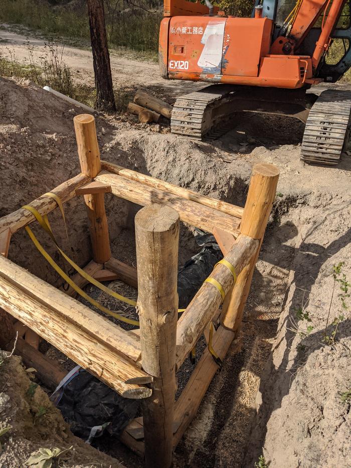 Back on the pumphouse project - we needed more room to attach the siding logs/shoring and decided to move the frame instead of digging ourselves in deeper. The trackhoe picked it up a couple inches and we were on our way. 