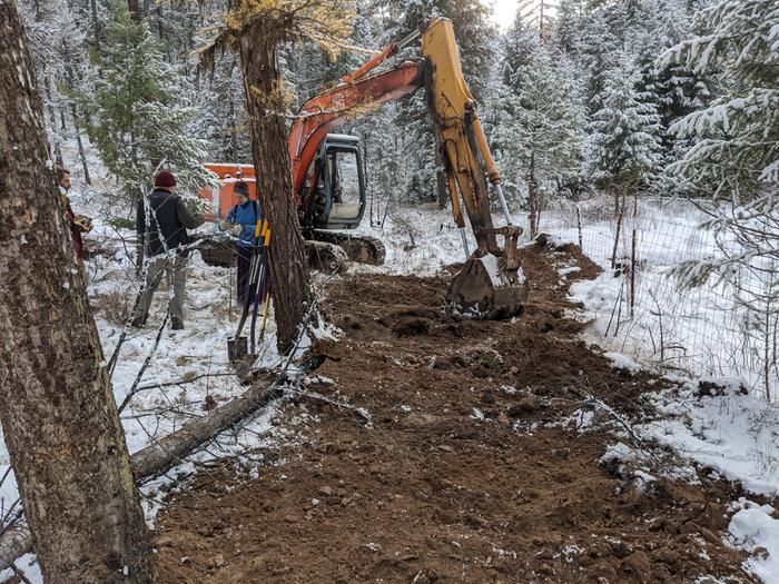 After a little trackhoe sled ride down the hill (the one to the left that cant be seen) and squeezing between a couple trees, we managed to back fill the remaining stretch of waterline. 