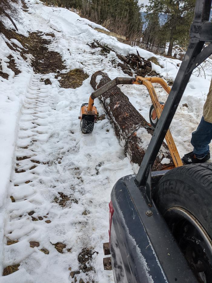 Moving a 10'x14" log down a snowy narrow road. 