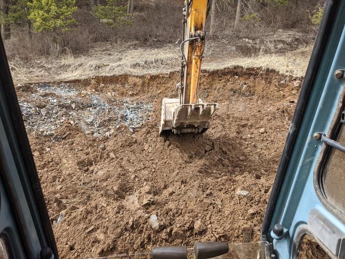 The excavator met its match and without a hammer attachment to deal with the bed rock we needed to cut losses and alter course. If you can dig down, build up. 