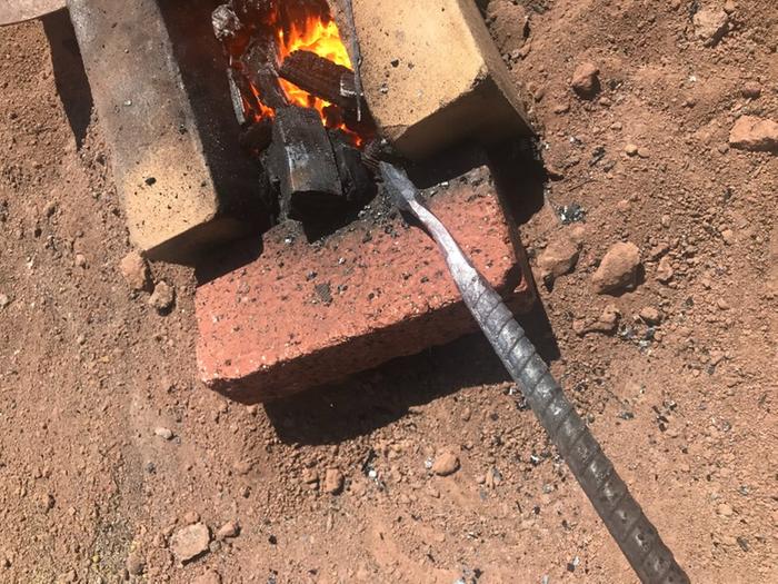 rebar being heated in a brick forge