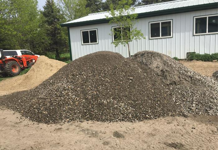 Piles of crushed urbanite in front of a steel building
