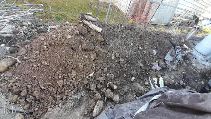 dirt pile excavated to make a trench for a sewer line