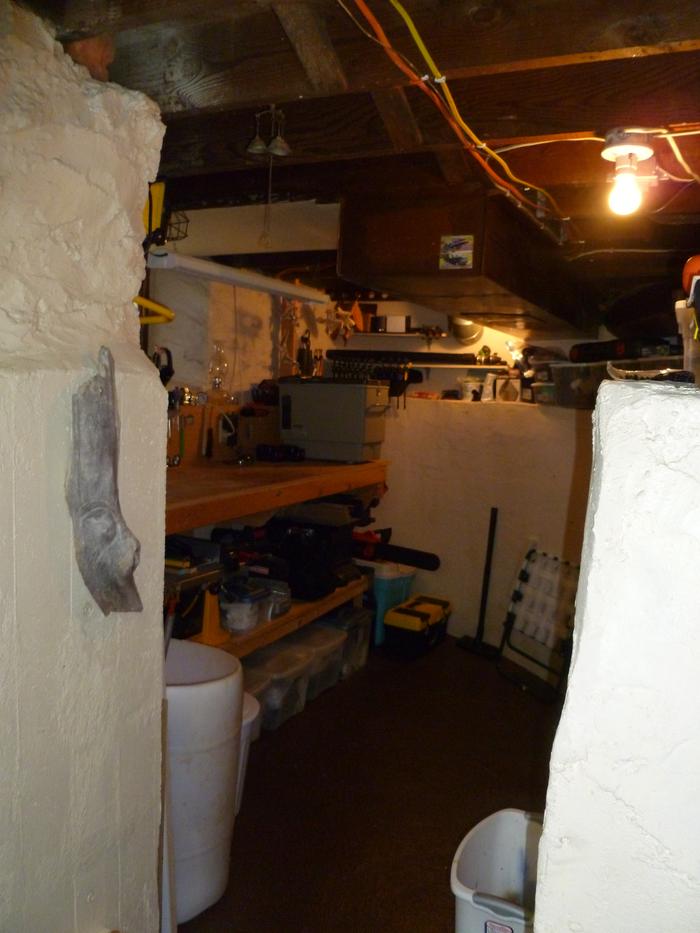 Old cistern in basement, one side opened for storage room