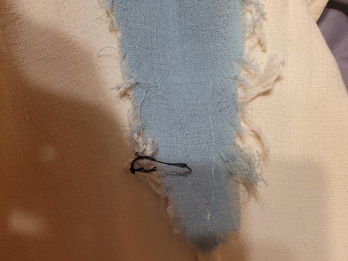 Raw unraveling edges before trimming loose threads+