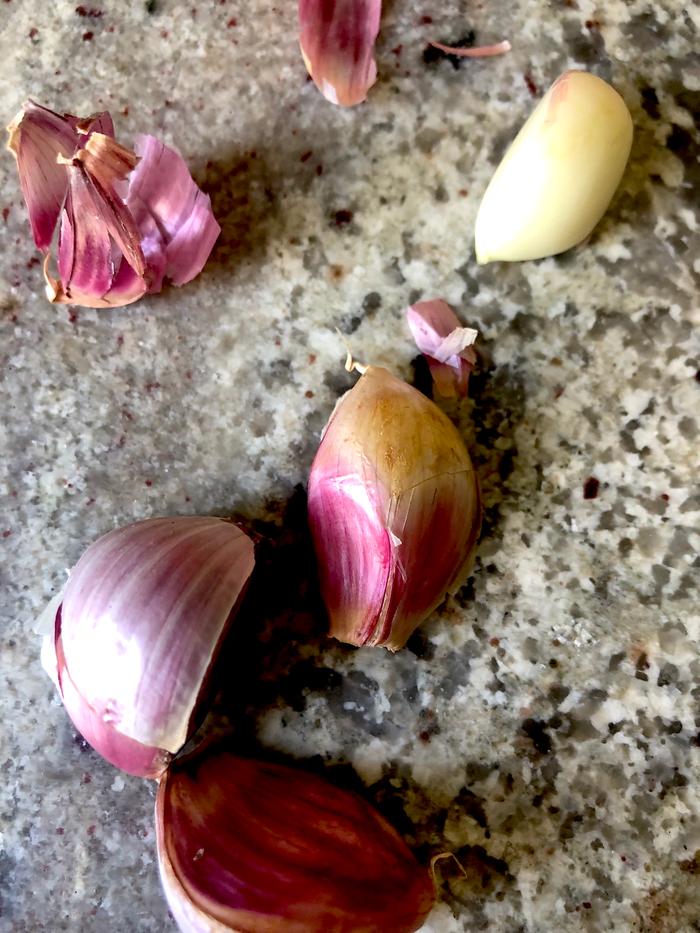 closeup cloves of garlic on granite countertop