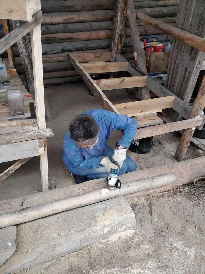 Julia working on flattening an area of a round pole