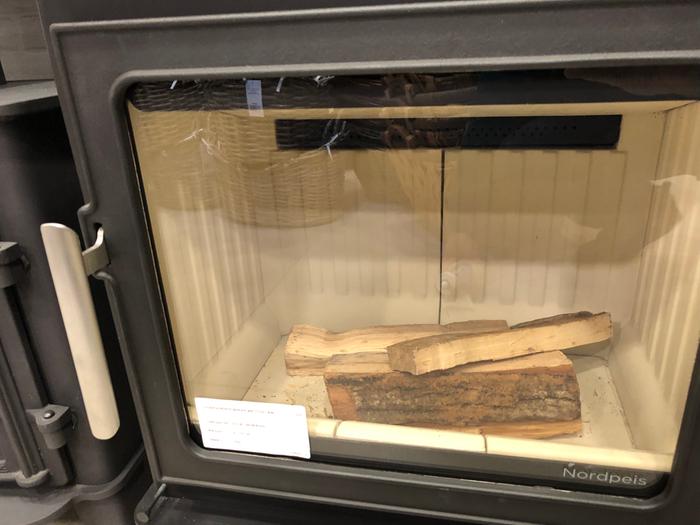 Small pieces of firewood in a wood stove lined by vermiculite