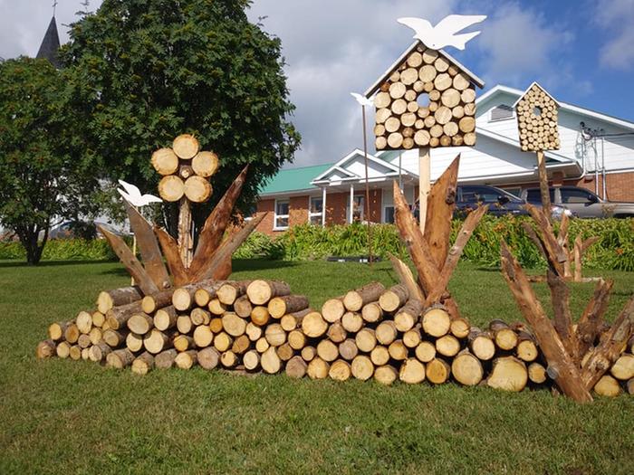 Firewood stacked as birdhouses and grass
