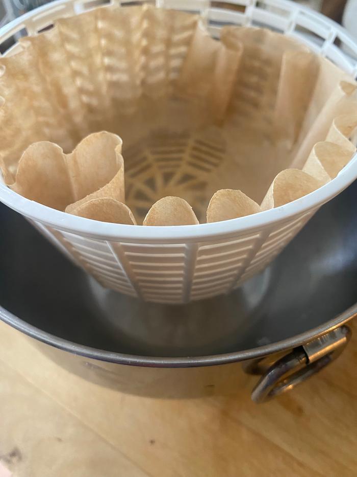 I prepared a new coffee filter in the cheese basket, setting it atop a custard cup inside a bowl to drain and firm the cheese again.