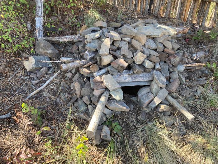 Cat shelter made from rocks. Cat eyes peeking out