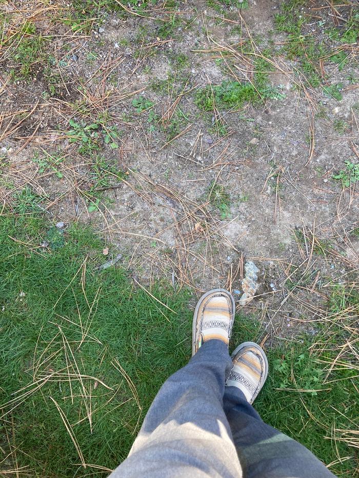 Wool slacks and cotton surf loafers outdoors in the sandy lot