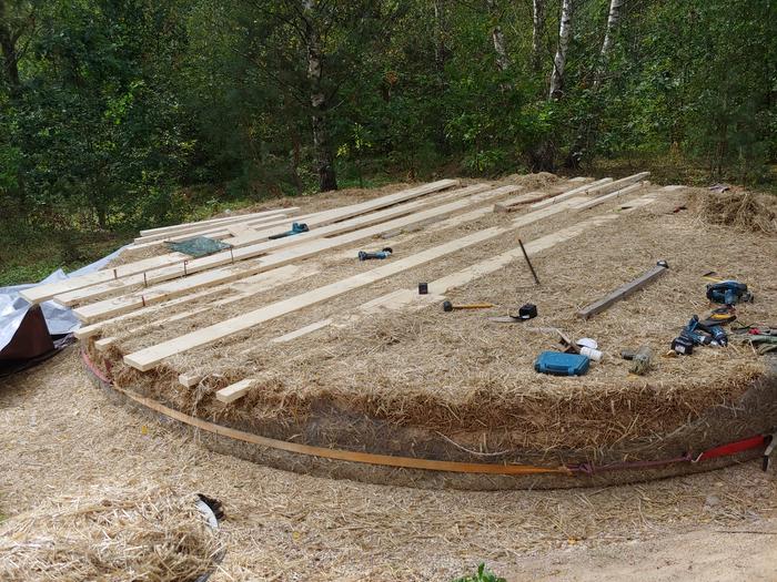 Because the strawbales were facing straw-side up, neither saw nor strimmer couldn't cut the straw so I used an angle grinder w/ metal cutting plate to cut into the bales to let in 10x25cm boards