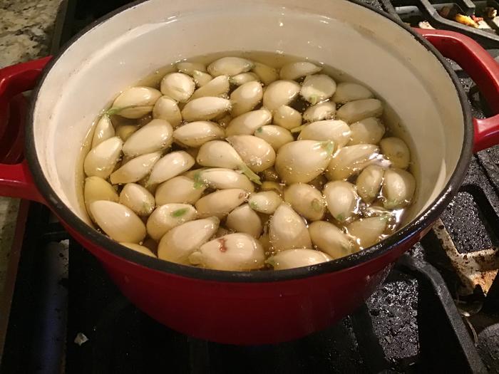 Transfer the confit garlic to sterile mason jars and cover them with the oil