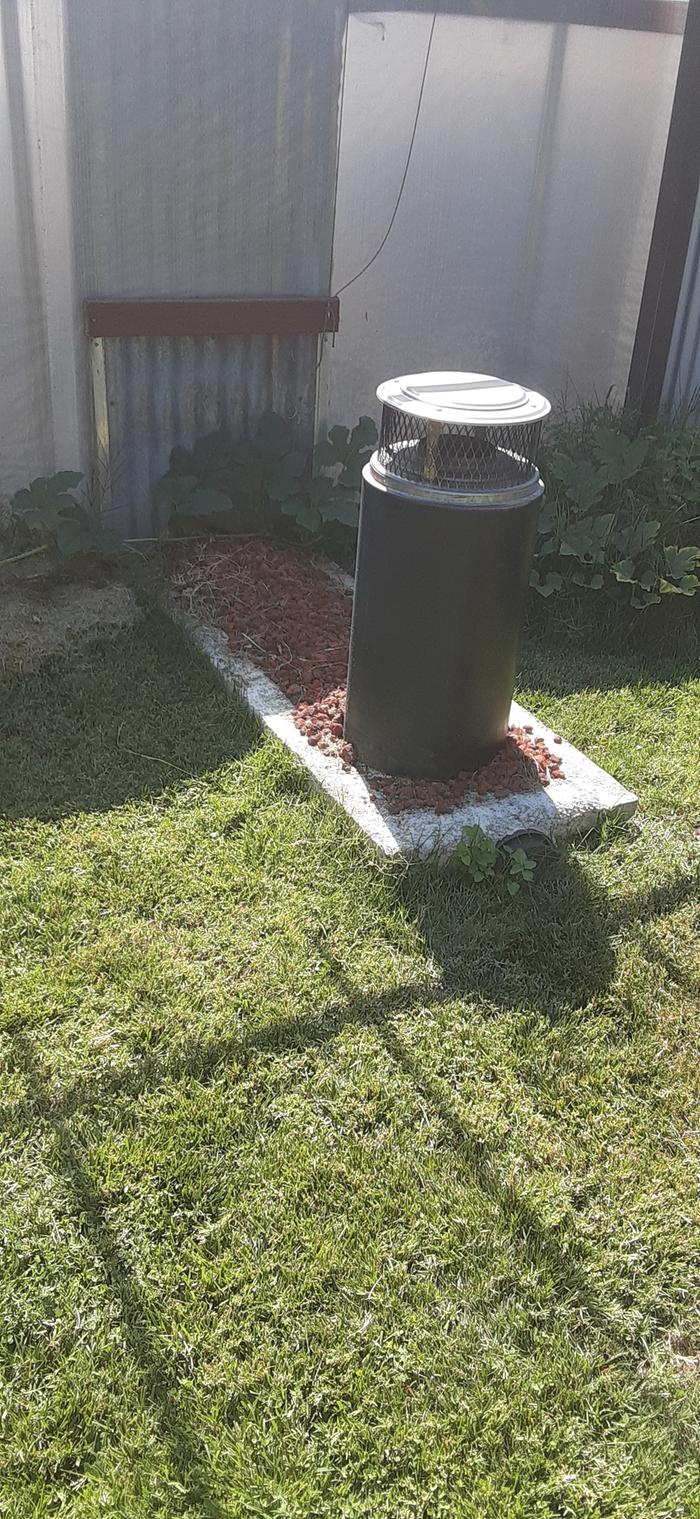 stove system in ground with a stove pipe popping up