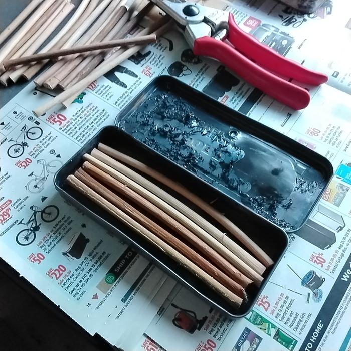 Dry Grape vines going into charcoal making tin made from old geometry set