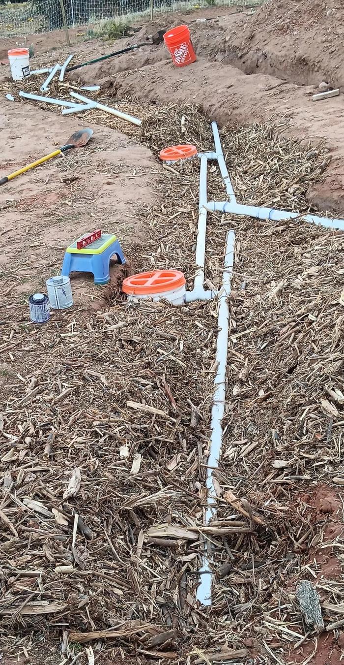 buckets and pipes in wood chips for the drainfield of a permitted worm bin septic system