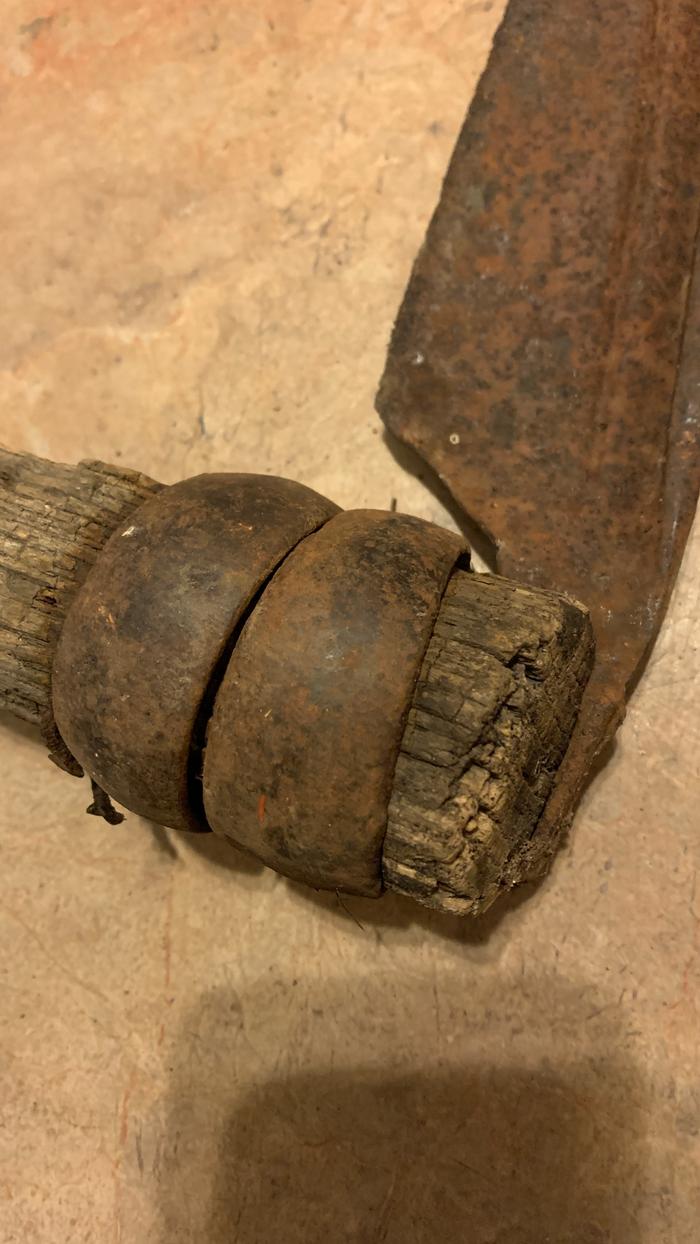 Closeup of the attachment point of an American scythe to a double ring bush snath