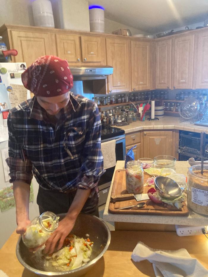 Stuffing salad into a fermentation jar