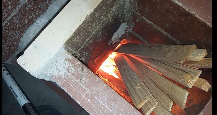 kindling burning in j-tube of rocket mass heater