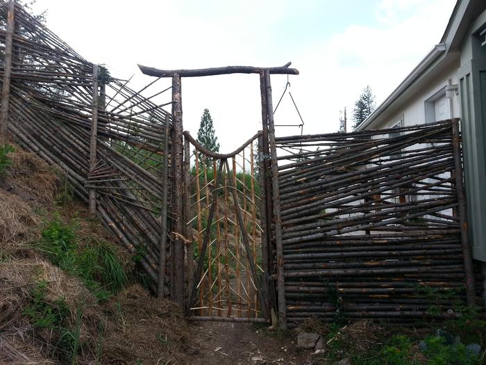 artistically updated junk pole fencing adjacent to the new gate